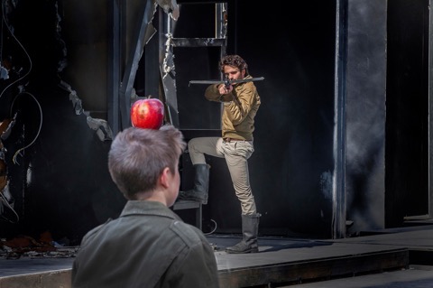 Im Vordergrund ein Junge mit einem roten Apfel auf dem Kopf, im Hintergrund ein Mann mit Armbrust; © Andy Stueckl, Passionstheater Oberammergau